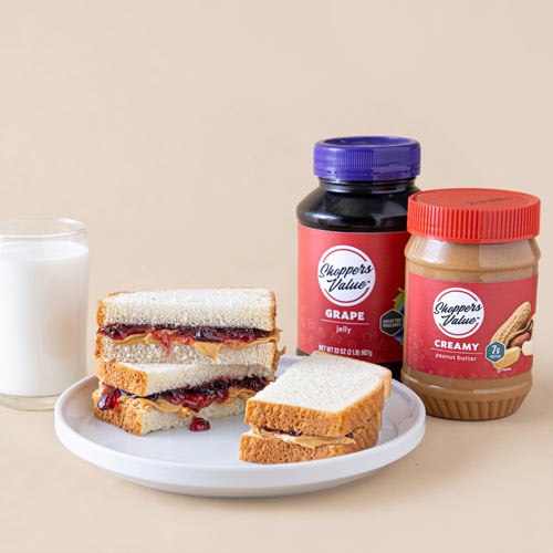 Shoppers Value Peanut Butter and Jelly products next to peanut butter and jelly sandwich.